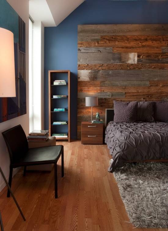 Большое деревянное изголовье и стильная мебель в  спальне