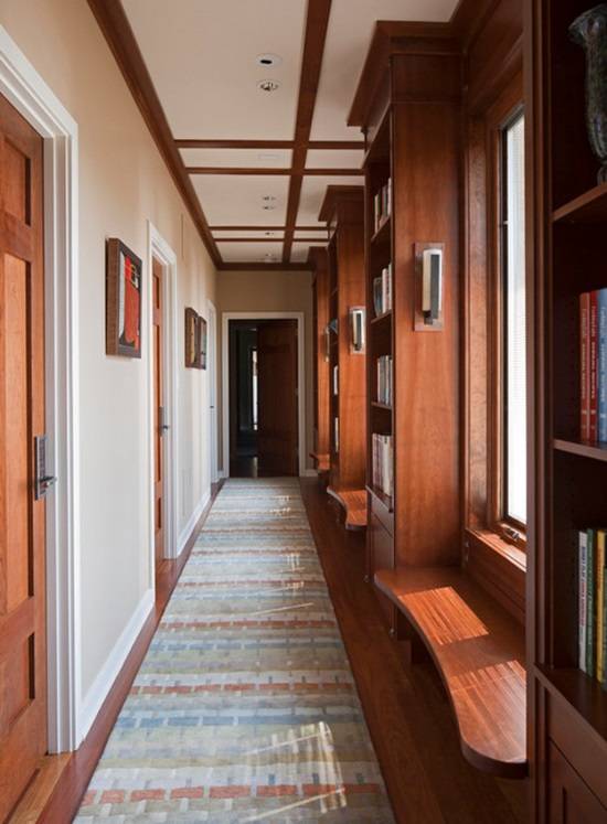 Домашняя библиотека в коридоре с окнами