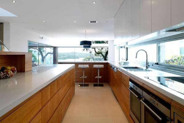 Белый с коричневым современный интерьер кухни с окном в частном доме 
